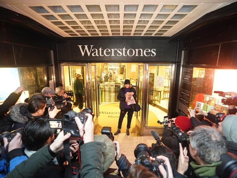 Caroline Lennon, the first and only customer in the queue when the store opened to purchase a copy of Spare, the newly released autobiography from the Duke of Sussex, poses for photographers with her copy of the book