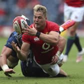Duhan van der Merwe, who scored a try on his Lions debut, is tackled by Japan's Lappies Labuschagne.