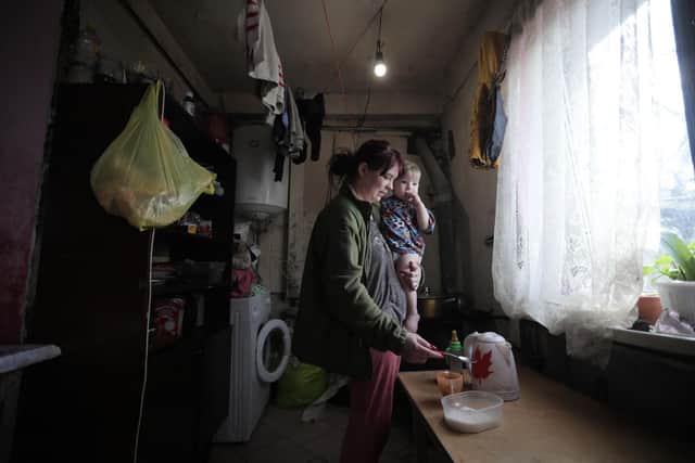 Julia, 27, holds her baby as she prepares a cup of tea in the small town of Krasnogorivka, Donetsk region, which was taken by pro-Russian separatists, then retaken by Ukrainian government forces (Picture: Aleksey Filippov/AFP via Getty Images)