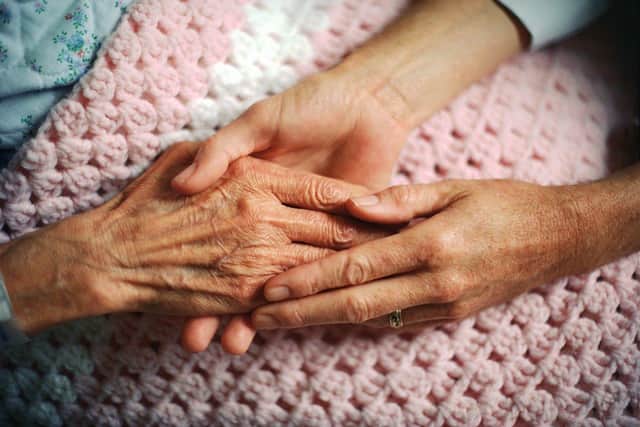 A geriatrician holds the hand of an elderly woman with arthritis. Picture: Corbis