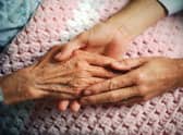 A geriatrician holds the hand of an elderly woman with arthritis. Picture: Corbis