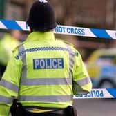 Generic police tape crime scene cordoned off emergency services. Police officer at scene