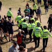 Police Officers remove Just Stop Oil protesters from the course, after interrupting play and throwing orange paint and glitter onto the edges of the green on the 17th hole.