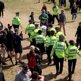 Police Officers remove Just Stop Oil protesters from the course, after interrupting play and throwing orange paint and glitter onto the edges of the green on the 17th hole.