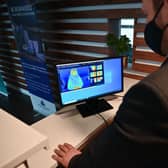 A staff member looks at a thermal image of a guest in a quarantine hotel