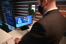 A staff member looks at a thermal image of a guest in a quarantine hotel