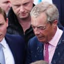 Chaidh bainne a thilgeil air Nigel Farage agus e ag iomairt am measg nan daoine. (Dealbh: Carl Court/Getty Images)