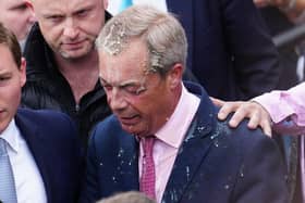 Chaidh bainne a thilgeil air Nigel Farage agus e ag iomairt am measg nan daoine. (Dealbh: Carl Court/Getty Images)