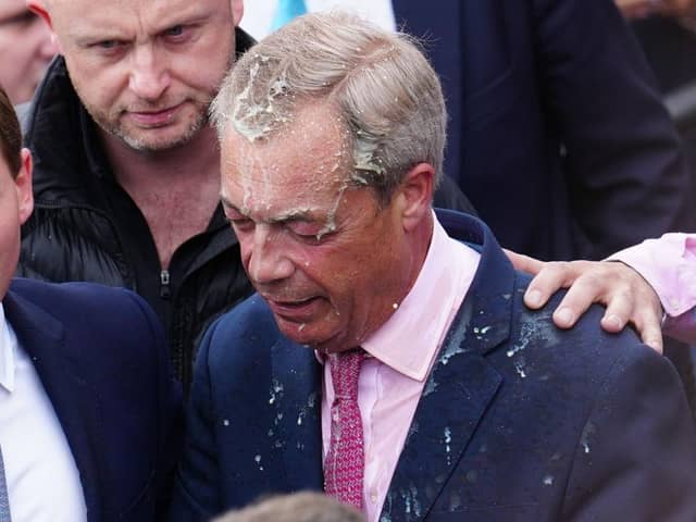 Chaidh bainne a thilgeil air Nigel Farage agus e ag iomairt am measg nan daoine. (Dealbh: Carl Court/Getty Images)
