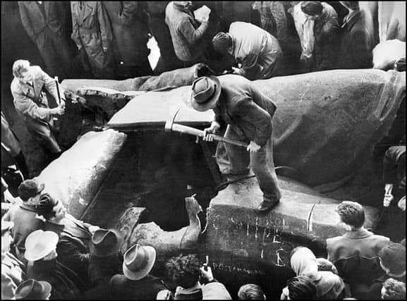 Residents of Budapest in 1956 destroy a huge statue of Stalin in the Hungarian capital during a demonstration against the communist domination (Picture: AFP via Getty Images)
