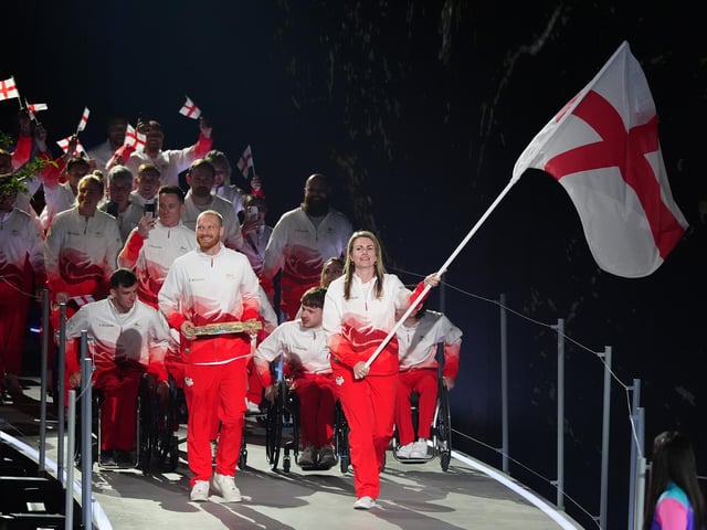 Sian Honnor, flag bearer of England alongside Luke Greenbank, baton bearer leads their delegation