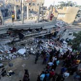 People search through buildings, destroyed during Israeli air raids in the southern Gaza Strip.