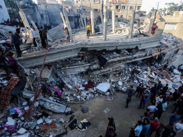 People search through buildings, destroyed during Israeli air raids in the southern Gaza Strip.