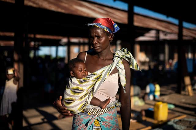 Malita, 35, stands with her four-month old son, Joseph*, in the hanger where she sleeps in the Bangula camp, southern Malawi, on April 1, 2019.