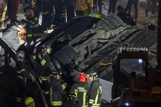 Emergency crew members work at the scene after a bus accident near Venice. A bus belonging to the transport company La Linea plunged from an overpass between Mestre and Marghera.