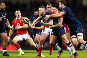 Scotland's Finn Russell (centre) is tackled by Wales' Josh Adams during the Guinness Six Nations match at the Principality Stadium, Cardiff. Picture date: Saturday February 3, 2024.