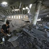 A man looks at damaged books inside a mosque destroyed in an Israeli air strike in Khan Younis, Gaza Strip. The Hamas militants broke out of the blockaded Gaza Strip and rampaged through nearby Israeli communities, taking captives, while Israel's retaliation strikes leveled buildings in Gaza. (AP Photo/Yousef Masoud)