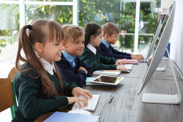 Children using tablets and desktop computers in class