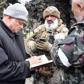 Konstantin Ivashchenko, former CEO of the Azovmash plant and newly appointed pro-Russian mayor of Mariupol writes notes flanked by his bodyguards, in Mariupol.