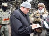 Konstantin Ivashchenko, former CEO of the Azovmash plant and newly appointed pro-Russian mayor of Mariupol writes notes flanked by his bodyguards, in Mariupol.