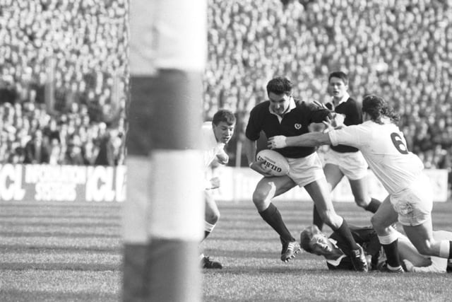 Sean Lineen fends off England's Mike Stanger watched by a grounded Craig Chalmers during the Scotland v England match.