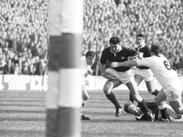 Sean Lineen fends off England's Mike Stanger watched by a grounded Craig Chalmers during the Scotland v England match.
