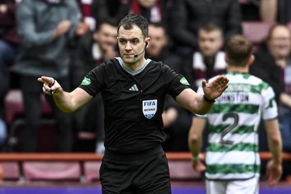 Referee Don Robertson is called to the VAR monitor before awarding a penalty to Hearts for a handball by Celtic's Tomoki Iwata.