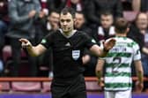 Referee Don Robertson is called to the VAR monitor before awarding a penalty to Hearts for a handball by Celtic's Tomoki Iwata.