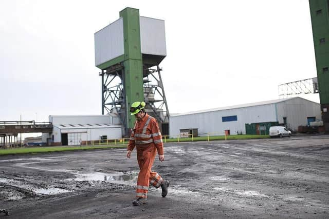 A coal miner walks through the site at Kellingley Colliery in Yorkshire, northern England, on December 18, 2015, on the mine's last operational day (Picture; Oli Scarff/AFP via Getty Images)