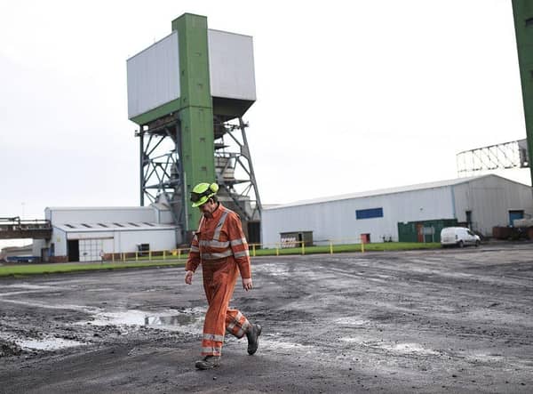 A coal miner walks through the site at Kellingley Colliery in Yorkshire, northern England, on December 18, 2015, on the mine's last operational day (Picture; Oli Scarff/AFP via Getty Images)