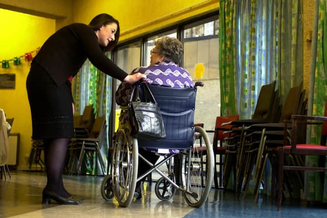 Nurse in a care home talking to an elderly woman in a wheelchair (Photo: Esme Allen).
