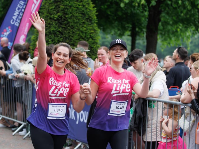 These two women enjoy the moment as the race floods Glasgow with runners, many who have been directly affected by the disease . PIC: Steve Welsh.