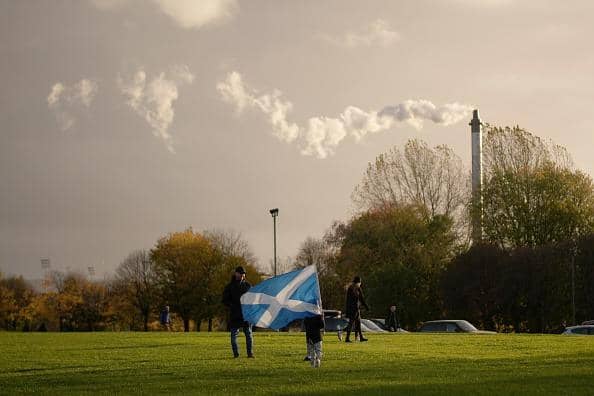 A child waves a saltire flag as pollution spills from a chimney at Glasgow Green as climate protestors gather for the Global Day of Action for Climate Justice march on November 06, 2021. Picture: Christopher Furlong/Getty Images