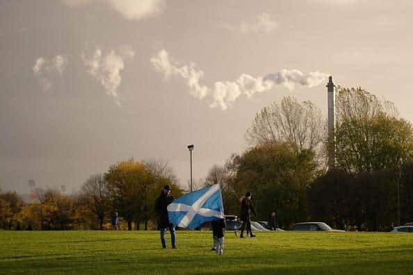 A child waves a saltire flag as pollution spills from a chimney at Glasgow Green as climate protestors gather for the Global Day of Action for Climate Justice march on November 06, 2021. Picture: Christopher Furlong/Getty Images