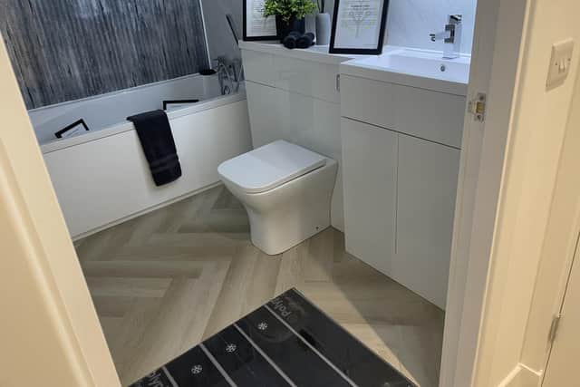 The bathroom in the Net Zero Home includes a system that collects used bathwater and recirculates it to provide warmth and underfloor heating, usually hidden, can be seen
