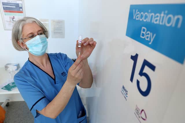 Gillian Bruce loads a syringe with a vaccine at Forth Valley College's Stirling campus. Scotland has vaccinated over 2.5 million people with a first dose.
