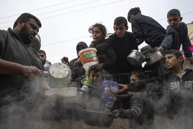 Children wait to receive a meal in Rafah, Gaza Strip, amid severe shortages of food and other essentials (Picture: Fatima Shbair/Associated Press)