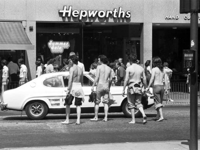 Four teenagers stripped to the waist and in bare feet crossing Princes Street Edinburgh during the long hot summer of 1976.