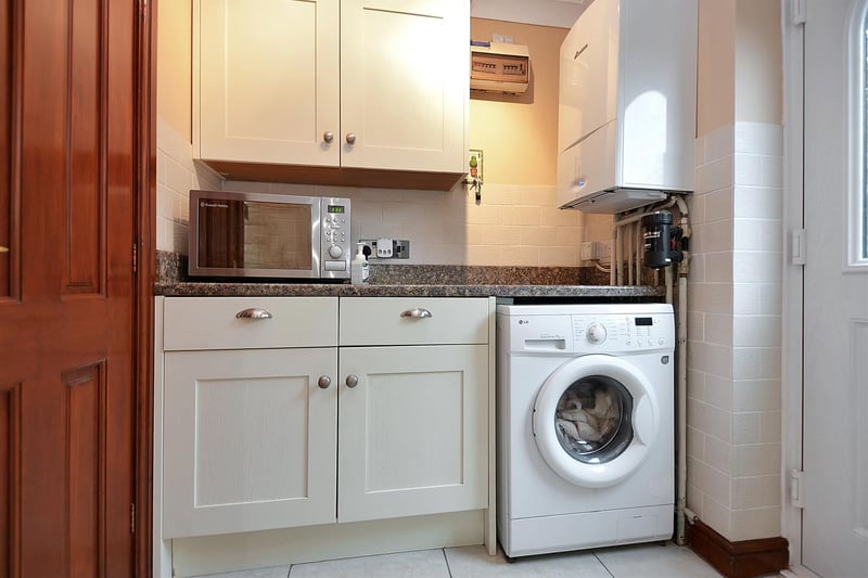 There are contemporary wall and base units, granite-effect work surfaces and plumbing for a washing machine.