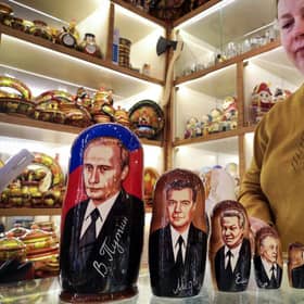 A vendor stands next to traditional Russian wooden nesting dolls, Matryoshka dolls, depicting Russian President Vladimir Putin (From L) and his predecessor  - Dmitry Medvedev, Boris Yeltsin, Mikhail Gorbachev and Leonid Brezhnev at a gift shop in Moscow this week.