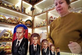 A vendor stands next to traditional Russian wooden nesting dolls, Matryoshka dolls, depicting Russian President Vladimir Putin (From L) and his predecessor  - Dmitry Medvedev, Boris Yeltsin, Mikhail Gorbachev and Leonid Brezhnev at a gift shop in Moscow this week.