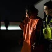 A man is escorted by Border Force officials after being picked up in the channel with other migrants on the south coast of England.