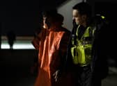 A man is escorted by Border Force officials after being picked up in the channel with other migrants on the south coast of England.