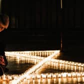 Verger Jessica Cook lights six hundred candles set out on the floor in the form of the Star of David during a special event to commemorate Holocaust Memorial Day 2018 in York Minster (Photo: Ian Forsyth/Getty Images)
