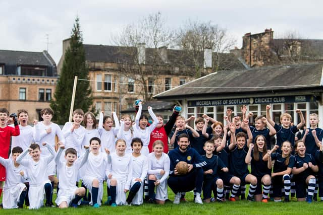 Scotland goalkeeper Craig Gordon poses with children from Hyndland Primary School - and clutches an old-style ball - at an event to mark the 150th anniversary of the first Scotland v England international fixture in 1872 at the West of Scotland Cricket Ground (Photo by Ross Parker / SNS Group)