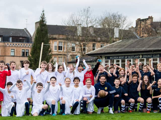 Scotland goalkeeper Craig Gordon poses with children from Hyndland Primary School - and clutches an old-style ball - at an event to mark the 150th anniversary of the first Scotland v England international fixture in 1872 at the West of Scotland Cricket Ground (Photo by Ross Parker / SNS Group)