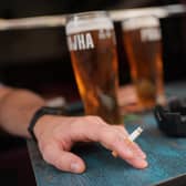 A person smoking a cigarette outdoors in a pub. PIC: Yui Mok/PA Wire