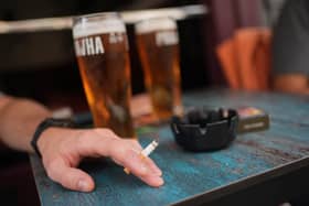 A person smoking a cigarette outdoors in a pub. PIC: Yui Mok/PA Wire