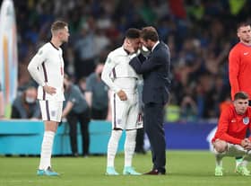 England manager Gareth Southgate consoles Jadon Sancho following defeat in the penalty shoot-out after the UEFA Euro 2020 Final at Wembley Stadium, London.