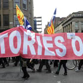 Protesters at a 2015 rally in Glasgow against the Trident nuclear programme carry a banner that reads 'Red Tories out' (Picture: Andy Buchanan/AFP via Getty Images)